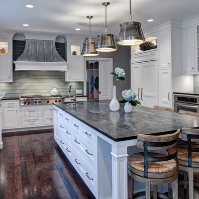 Eat-in kitchen - transitional u-shaped eat-in kitchen idea in Chicago with a farmhouse sink, white cabinets, soapstone countertops, green backsplash, glass tile backsplash, recessed-panel cabinets and paneled appliances