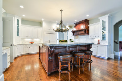 Inspiration for a mid-sized transitional u-shaped dark wood floor enclosed kitchen remodel in Atlanta with a double-bowl sink, recessed-panel cabinets, white cabinets, quartz countertops, white backsplash, stone tile backsplash, colored appliances and an island
