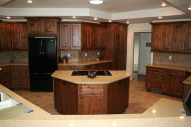 Foto på ett mellanstort vintage kök och matrum, med luckor med upphöjd panel, skåp i mörkt trä, laminatbänkskiva, beige stänkskydd, stänkskydd i keramik, svarta vitvaror, klinkergolv i keramik, en köksö och brunt golv