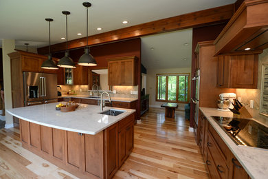 Inspiration for a large rustic l-shaped light wood floor and beige floor kitchen pantry remodel in Cleveland with an undermount sink, shaker cabinets, medium tone wood cabinets, marble countertops, beige backsplash, stone tile backsplash, stainless steel appliances and an island