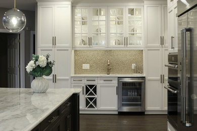 Photo of a large traditional l-shaped open plan kitchen in DC Metro with a belfast sink, recessed-panel cabinets, white cabinets, engineered stone countertops, yellow splashback, glass tiled splashback, stainless steel appliances, dark hardwood flooring, an island, grey floors and white worktops.