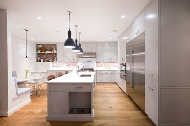 Large transitional l-shaped medium tone wood floor and brown floor eat-in kitchen photo in Auckland with an undermount sink, flat-panel cabinets, gray cabinets, quartz countertops, brown backsplash, brick backsplash, stainless steel appliances, an island and white countertops