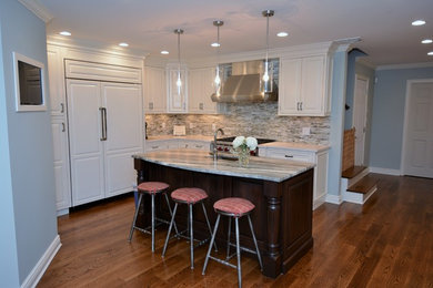 Example of a transitional l-shaped dark wood floor eat-in kitchen design in Boston with recessed-panel cabinets, white cabinets, multicolored backsplash, ceramic backsplash, paneled appliances, an island and a farmhouse sink
