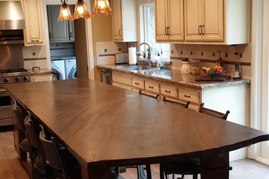 Large transitional u-shaped medium tone wood floor open concept kitchen photo in Orange County with an undermount sink, raised-panel cabinets, distressed cabinets, granite countertops, white backsplash, ceramic backsplash, white appliances and an island