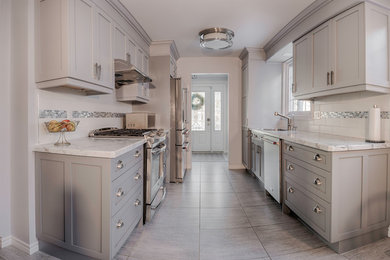Photo of a medium sized classic galley open plan kitchen in Toronto with a submerged sink, shaker cabinets, grey cabinets, engineered stone countertops, white splashback, ceramic splashback, stainless steel appliances, ceramic flooring, no island, grey floors and white worktops.