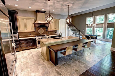 Open concept kitchen - large transitional l-shaped limestone floor and gray floor open concept kitchen idea in Cleveland with an undermount sink, raised-panel cabinets, beige cabinets, granite countertops, brown backsplash, ceramic backsplash, stainless steel appliances and an island
