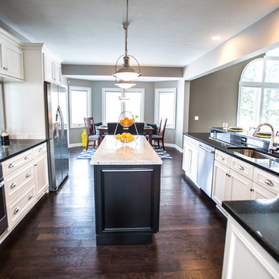 Mid-sized transitional u-shaped eat-in kitchen photo in Cleveland with an undermount sink, shaker cabinets, white cabinets, granite countertops, white backsplash, subway tile backsplash, stainless steel appliances and an island