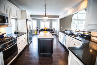 Mid-sized transitional u-shaped eat-in kitchen photo in Cleveland with an undermount sink, shaker cabinets, white cabinets, granite countertops, white backsplash, subway tile backsplash, stainless steel appliances and an island