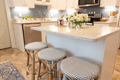 Example of a mid-sized transitional u-shaped beige floor enclosed kitchen design in Boston with an undermount sink, recessed-panel cabinets, white cabinets, blue backsplash, subway tile backsplash, stainless steel appliances, an island and beige countertops