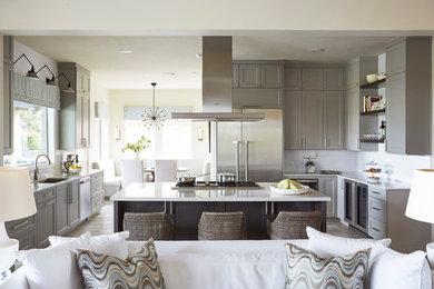 Inspiration for a transitional u-shaped beige floor open concept kitchen remodel in Houston with an undermount sink, shaker cabinets, gray cabinets, white backsplash, subway tile backsplash, stainless steel appliances and an island