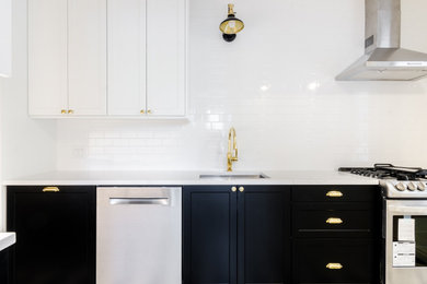 Inspiration for a mid-sized modern galley ceramic tile and white floor eat-in kitchen remodel in New York with an undermount sink, shaker cabinets, black cabinets, marble countertops, white backsplash, subway tile backsplash, stainless steel appliances, white countertops and no island