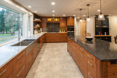 Inspiration for a large contemporary u-shaped beige floor and porcelain tile open concept kitchen remodel in Other with a farmhouse sink, flat-panel cabinets, medium tone wood cabinets, subway tile backsplash, an island, quartzite countertops, black backsplash and stainless steel appliances