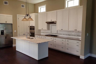 Inspiration for a mid-sized transitional l-shaped open concept kitchen remodel in Austin with an undermount sink, beaded inset cabinets, white cabinets, white backsplash, ceramic backsplash, stainless steel appliances and an island