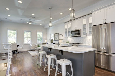 Large transitional single-wall dark wood floor and brown floor eat-in kitchen photo in Other with an undermount sink, shaker cabinets, white cabinets, marble countertops, gray backsplash, marble backsplash, stainless steel appliances and an island