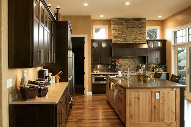 Example of a large transitional l-shaped dark wood floor kitchen design in Other with an undermount sink, recessed-panel cabinets, dark wood cabinets, stainless steel appliances and an island