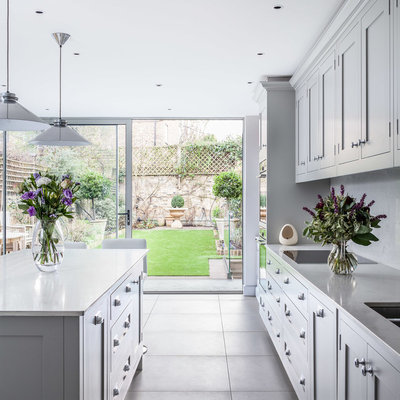 Example of a transitional kitchen design in London with shaker cabinets, gray cabinets, quartzite countertops, a double-bowl sink and an island