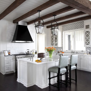 Large transitional open concept kitchen remodeling - Inspiration for a large transitional l-shaped dark wood floor and exposed beam open concept kitchen remodel in New Orleans with a farmhouse sink, white cabinets, an island, marble countertops, white backsplash, stone slab backsplash, stainless steel appliances, white countertops and shaker cabinets