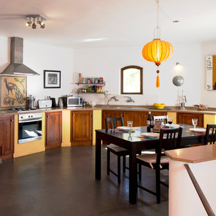 Foto de cocina comedor lineal, tradicional renovada, grande, sin isla, con armarios estilo shaker, puertas de armario de madera en tonos medios, salpicadero blanco, electrodomésticos de acero inoxidable y suelo de pizarra