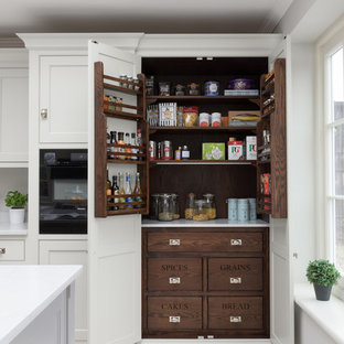 Inspiration for a large classic l-shaped kitchen pantry in Other with shaker cabinets, white cabinets, black appliances, an island, beige floors and white worktops.