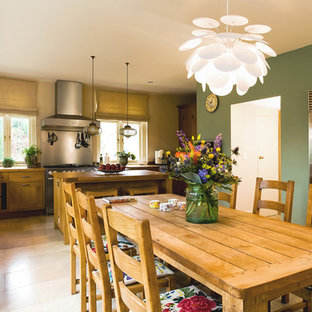 Ejemplo de cocina comedor tradicional renovada con electrodomésticos de acero inoxidable, fregadero encastrado, puertas de armario de madera oscura y encimera de madera