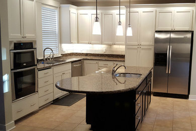 Mid-sized transitional u-shaped ceramic tile eat-in kitchen photo in Seattle with a double-bowl sink, flat-panel cabinets, white cabinets, granite countertops, white backsplash, ceramic backsplash, stainless steel appliances and an island