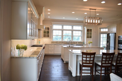 Huge transitional u-shaped dark wood floor and brown floor eat-in kitchen photo in Other with a farmhouse sink, beaded inset cabinets, white cabinets, granite countertops, white backsplash, stainless steel appliances and two islands