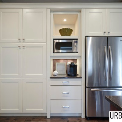 Transitional u-shaped medium tone wood floor and brown floor eat-in kitchen photo in Other with shaker cabinets, white cabinets, granite countertops, an island, brown backsplash, stainless steel appliances and an undermount sink