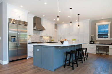 Example of a large transitional medium tone wood floor open concept kitchen design in San Francisco with an undermount sink, shaker cabinets, white cabinets, marble countertops, gray backsplash, subway tile backsplash, stainless steel appliances and an island