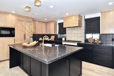 Example of a large transitional u-shaped light wood floor and beige floor eat-in kitchen design in Orange County with a single-bowl sink, shaker cabinets, light wood cabinets, marble countertops, black backsplash, cement tile backsplash, white appliances, an island and black countertops
