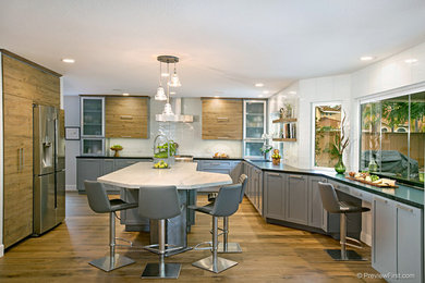 サンディエゴにある中くらいなトランジショナルスタイルのおしゃれなL型キッチン (シェーカースタイル扉のキャビネット、グレーのキャビネット、白いキッチンパネル、サブウェイタイルのキッチンパネル、シルバーの調理設備) の写真