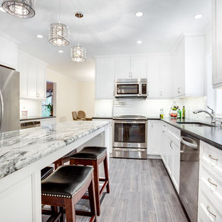 Large transitional kitchen ideas - Example of a large transitional u-shaped kitchen design in DC Metro with an undermount sink, recessed-panel cabinets, white cabinets, granite countertops, white backsplash, subway tile backsplash, stainless steel appliances and an island