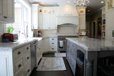 Inspiration for a large timeless l-shaped dark wood floor and brown floor enclosed kitchen remodel in Austin with a farmhouse sink, raised-panel cabinets, white cabinets, marble countertops, red backsplash, marble backsplash, stainless steel appliances, an island and white countertops