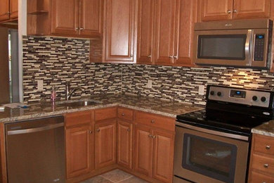 Inspiration for a mid-sized transitional l-shaped ceramic tile and beige floor enclosed kitchen remodel in Baltimore with an undermount sink, raised-panel cabinets, light wood cabinets, granite countertops, multicolored backsplash, matchstick tile backsplash, stainless steel appliances, no island and beige countertops