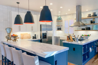 Example of a mid-sized transitional u-shaped medium tone wood floor open concept kitchen design in Denver with a farmhouse sink, flat-panel cabinets, turquoise cabinets, quartzite countertops, white backsplash, ceramic backsplash, stainless steel appliances and white countertops