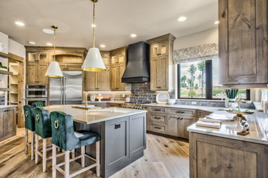 Large transitional l-shaped light wood floor and brown floor open concept kitchen photo in Denver with a double-bowl sink, recessed-panel cabinets, medium tone wood cabinets, granite countertops, brown backsplash, brick backsplash, stainless steel appliances, an island and beige countertops