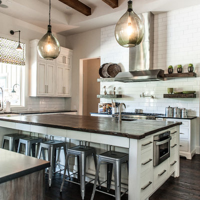 Example of a transitional u-shaped kitchen design in Austin with shaker cabinets, white cabinets, white backsplash, subway tile backsplash, stainless steel appliances and wood countertops