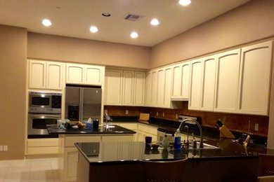 Inspiration for a large transitional u-shaped eat-in kitchen remodel in Phoenix with recessed-panel cabinets, white cabinets, granite countertops, metallic backsplash and an island