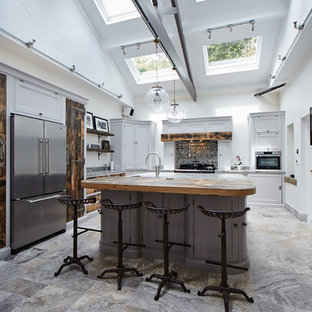 This is an example of a large classic l-shaped kitchen in Other with grey cabinets, stainless steel appliances, an island, recessed-panel cabinets, multi-coloured splashback, stone slab splashback and multi-coloured floors.