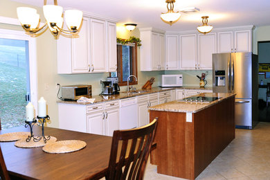 Immagine di una cucina classica di medie dimensioni con ante con bugna sagomata, ante bianche, top in granito, paraspruzzi verde, elettrodomestici in acciaio inossidabile e pavimento con piastrelle in ceramica