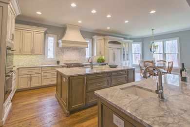 Large transitional l-shaped medium tone wood floor and brown floor eat-in kitchen photo with an undermount sink, gray backsplash, stainless steel appliances, two islands, beige cabinets, marble countertops and glass tile backsplash