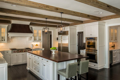 Example of a large transitional l-shaped dark wood floor eat-in kitchen design in Chicago with an undermount sink, recessed-panel cabinets, white cabinets, quartz countertops, white backsplash, ceramic backsplash, stainless steel appliances and an island