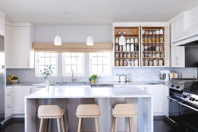 Mid-sized transitional u-shaped dark wood floor and brown floor eat-in kitchen photo in San Francisco with an undermount sink, raised-panel cabinets, white cabinets, marble countertops, white backsplash, stone slab backsplash, stainless steel appliances and an island
