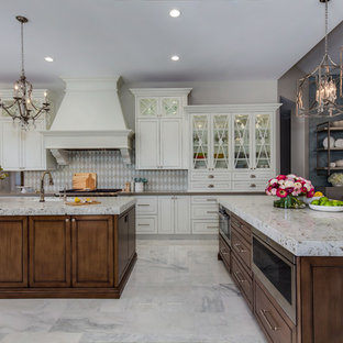 Inspiration for a large transitional open plan kitchen in Phoenix with an undermount sink, glass-front cabinets, white cabinets, recycled glass benchtops, white splashback, stainless steel appliances, marble floors, multiple islands and grey floor.