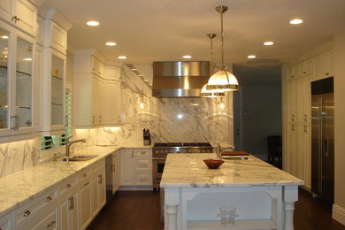 Large traditional u-shaped kitchen/diner in Miami with raised-panel cabinets, white cabinets, an island, a submerged sink, marble worktops, white splashback, stone slab splashback, stainless steel appliances and dark hardwood flooring.