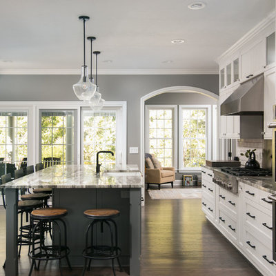 Large elegant dark wood floor and brown floor kitchen photo in Cleveland with a farmhouse sink, recessed-panel cabinets, white cabinets, stainless steel appliances, an island, subway tile backsplash, quartzite countertops and white backsplash