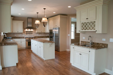 Example of a large classic u-shaped medium tone wood floor and brown floor eat-in kitchen design in Toronto with a drop-in sink, raised-panel cabinets, white cabinets, pink backsplash, stainless steel appliances, an island, granite countertops and subway tile backsplash