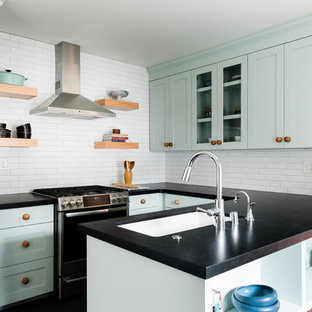 Mid-sized transitional eat-in kitchen appliance - Example of a mid-sized transitional u-shaped linoleum floor and blue floor eat-in kitchen design in Sacramento with shaker cabinets, blue cabinets, granite countertops, white backsplash, brick backsplash, stainless steel appliances, a peninsula, black countertops and an undermount sink