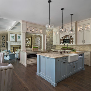 Transitional open concept kitchen photos - Inspiration for a transitional dark wood floor and brown floor open concept kitchen remodel in Detroit with a farmhouse sink, recessed-panel cabinets, blue cabinets, beige backsplash, beige countertops and an island