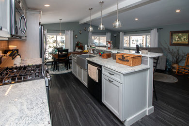 Inspiration for a mid-sized transitional galley vinyl floor and gray floor open concept kitchen remodel in Boston with recessed-panel cabinets, gray cabinets, granite countertops, an island, multicolored countertops, a farmhouse sink, gray backsplash, porcelain backsplash and stainless steel appliances