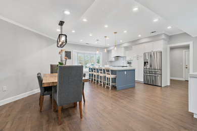 Mid-sized transitional u-shaped dark wood floor and brown floor eat-in kitchen photo in San Francisco with an undermount sink, recessed-panel cabinets, white cabinets, quartzite countertops, white backsplash, subway tile backsplash, stainless steel appliances, an island and white countertops